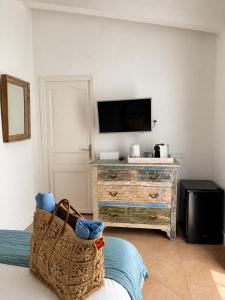 a living room with a television and a dresser at La Parenthèse de Villepey in Saint-Aygulf