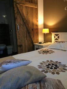 a bedroom with a large bed with a wooden wall at B&B - Pension Perruque in Koudum