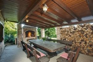 a patio with a wooden table and a fireplace at Podroom LauMarYvo in Dugo Selo