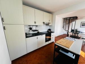a kitchen with white cabinets and a table in it at Le Petit Bourdieu - Chevreuil in Jurançon