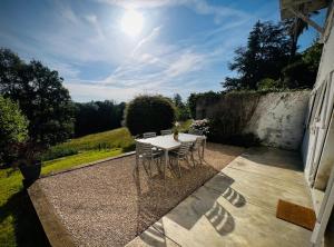a table and chairs sitting on a patio at Le Petit Bourdieu - Chevreuil in Jurançon +2 photos