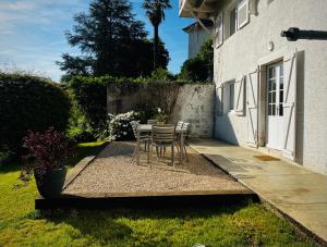 a table and chairs on the side of a house at Le Petit Bourdieu - Chevreuil in Jurançon