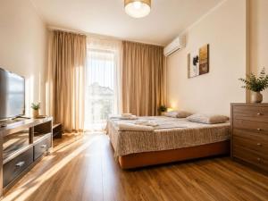 a bedroom with a large bed and a television at Europroperties Golden Line in Golden Sands +92 photos