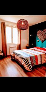 a bedroom with a bed and two hearts on the wall at Maison paisible en lisière de foret 9 personnes in Le Temple