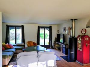 a living room with a couch and a red refrigerator at Maison paisible en lisière de foret 9 personnes in Le Temple