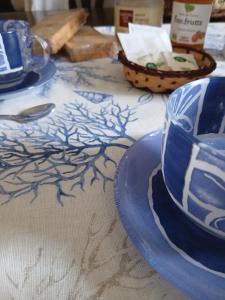 a table with blue plates and a tea cup on it at Casa venere in Pachino
