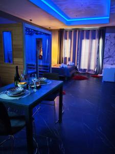 a blue room with a table with wine glasses on it at Suite Romantica con Jacuzzi e Sauna in Porto Empedocle
