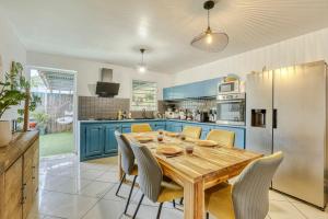 a kitchen with a wooden table and yellow chairs at Villa Cardinal in Saint-Louis