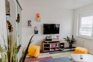 a living room with a tv on a white wall at Ferienwohnung Münch mit Balkon in Großheubach
