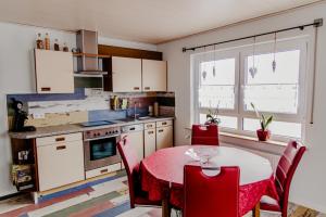 a kitchen with a red table and red chairs at Ferienwohnung Münch mit Balkon in Großheubach
