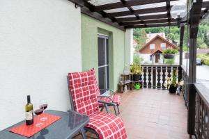 a patio with two chairs and a table with wine glasses at Ferienwohnung Münch mit Balkon in Großheubach