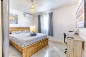 a bedroom with a bed and a desk at Villa Cardinal in Saint-Louis