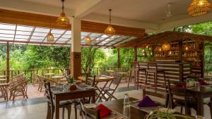 a restaurant with tables and chairs and a bar at Into The Wild Sigiriya in Sigiriya