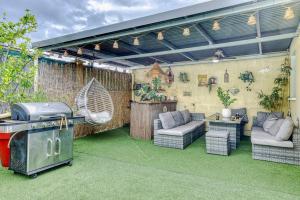 an outdoor entertaining area with a grill and chairs at Villa Cardinal in Saint-Louis