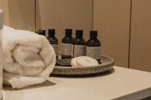 a tray with five bottles of alcohol on a bathroom counter at Arroyo Boutique&Business Hotel- By Star Hotels in Nahariyya +44 photos