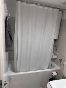 a bathroom with a shower with a white shower curtain at Residence 16 in Belgrade +6 photos