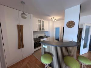 a kitchen with a counter and some green chairs at Residence 16 in Belgrade