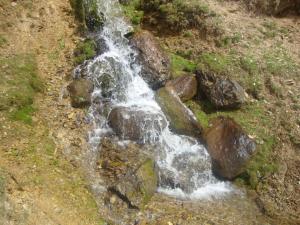 a waterfall on the side of a hill with rocks at Apart Heim in Fügen