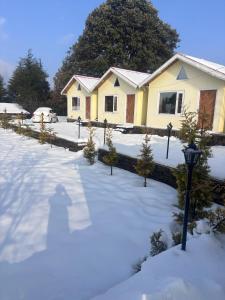 a house with a yard covered in snow at The Hideaway Chail in Chail