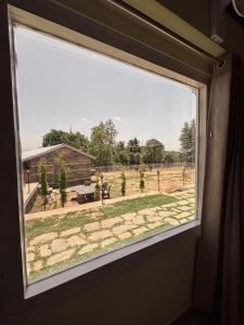 a window in a room with a view of a field at The Hideaway Chail in Chail