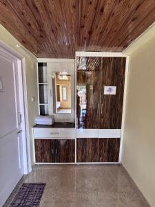 a bathroom with a glass shower with a wooden ceiling at The Hideaway Chail in Chail +27 photos