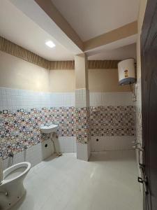 a bathroom with a toilet and a sink in it at Oliway Homestay in Lohaghāt +7 photos