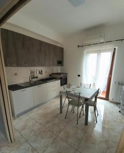 a kitchen with a table and chairs and a kitchen with a window at Dimora Melania in San Nicola Arcella