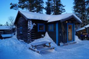 a log cabin with a bench in the snow at Värmlandsstugan in Sälen