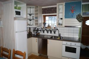 a kitchen with a sink and a white refrigerator at Värmlandsstugan in Sälen