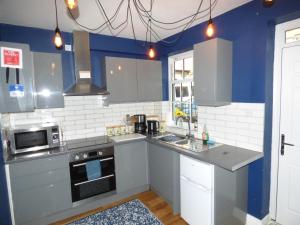 a kitchen with white appliances and blue walls at Entire home in perfect old town location in Hull
