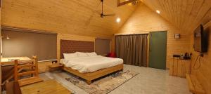 a bedroom with a bed and a desk in a room at Karibu Karjat Resort in Karjat