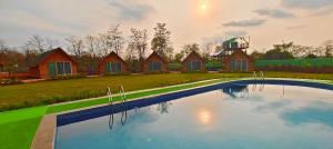 a large swimming pool in front of a house at Karibu Karjat Resort in Karjat