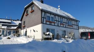 a building with snow in front of it at Gästehaus Stolzenberg in Hallenberg