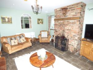 a living room with a brick fireplace at Eastfield Cottage free parking and EV charger in Leven