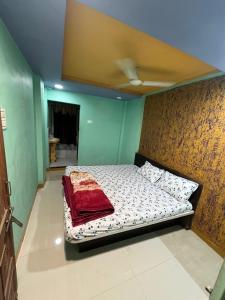 a bed in a room with a wall at Shri Vinayak Guest House Omkareshwar in Godarpura