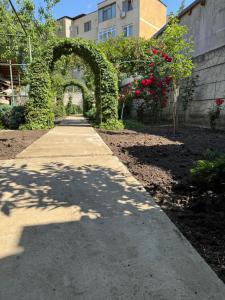 a walkway in a garden with an arch and roses at Villa Garden in Drobeta-Turnu Severin