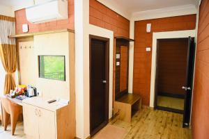 a room with a hallway with two doors and a table at HOTEL PARIJATHA Inn in Dharmastala