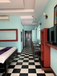 ein Zimmer mit einem Bett, einem Schreibtisch und einem Fernseher in der Unterkunft Saba Lua Siem Reap in Siem Reap