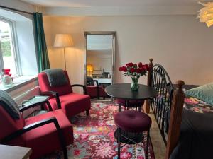 a living room with a couch and a table with flowers at BeBaBopS Homestay Sønderborg in Sønderborg