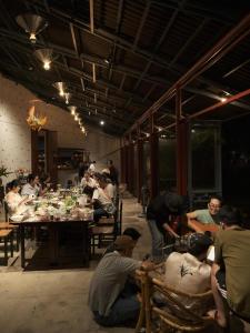 a group of people sitting around a table in a room at De Hué in Hue