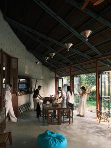 a group of people standing around a table in a room at De Hué in Hue