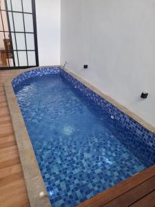 a swimming pool with blue tiles on the floor at Athara Naya in Karangploso
