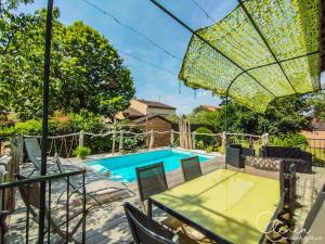 a patio with a table and chairs and a swimming pool at L'Escapade Albigeoise in Albi +22 photos