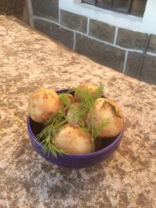 a blue bowl filled with potatoes on a counter at Holkestorp in Onslunda