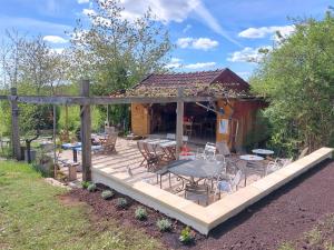 a deck with a table and chairs in front of a cabin at Glamping La Jonquille in Hurecourt