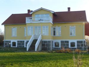 a large yellow house with stairs in a yard at Holkestorp in Onslunda
