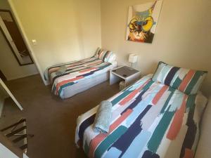 a room with two beds in a room with a bedskirts at Baybell Lodge in Tauranga +8 photos