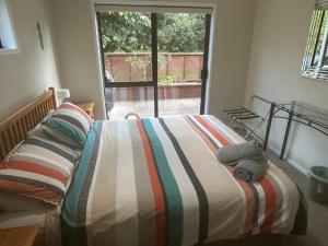 a bedroom with a bed with a stuffed animal on it at Baybell Lodge in Tauranga