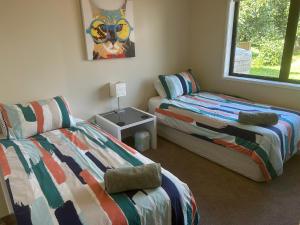a bedroom with two beds and a window at Baybell Lodge in Tauranga