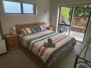 a bedroom with a bed with a towel on it at Baybell Lodge in Tauranga
